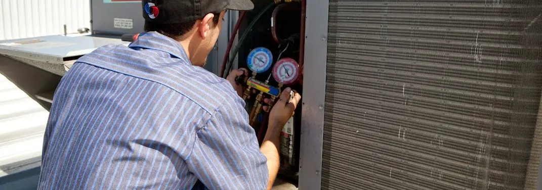 HVAC technician servicing a condenser unit in North Union